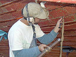 Setting in oakum in a hull seam