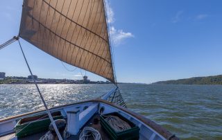 A photo of the Hudson River Sloop Clearwater's foredeck while sailing on a clear, sunny day on the Hudson River near Yonkers. Photo by Alon Koppel